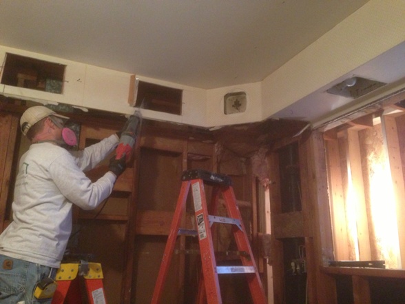 Worker with respirator sawing drywall
