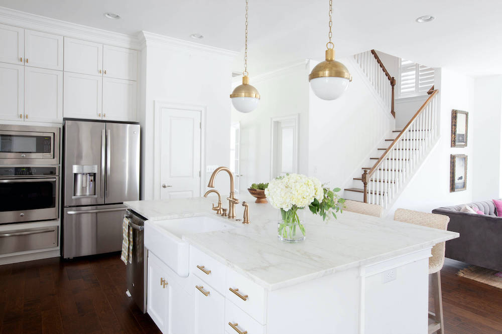 white kitchen with island, pendant lights, and cabinetry