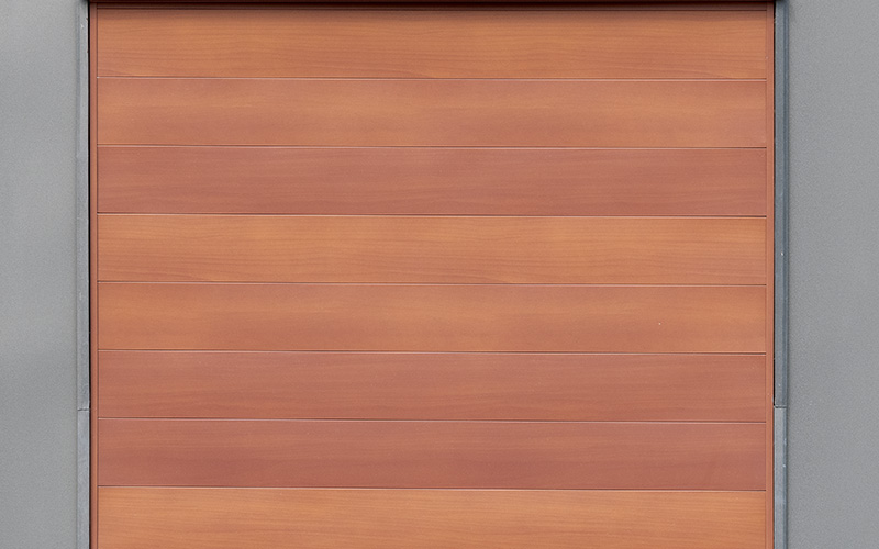 A close up shot of what appears to be a warm orange and brown sealed grained cedar wood, which is in fact metal siding from MAC Metal.
