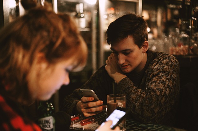 millennial man & woman with phones