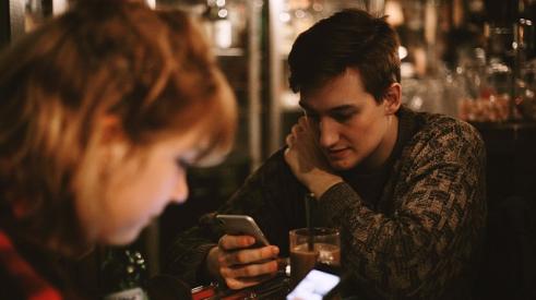 millennial man & woman with phones