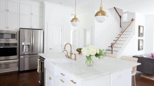 white kitchen with island, pendant lights, and cabinetry