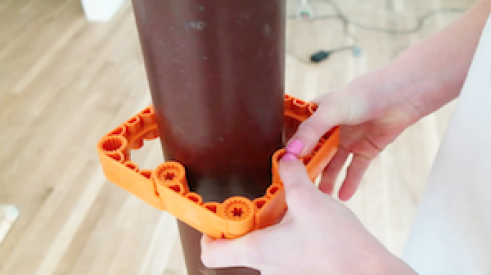 Close-up photo of the Simpliframe system being used around a pipe.